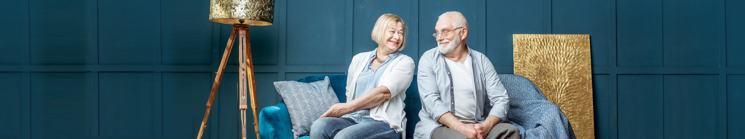 An older couple sitting comfortably on the sofa in their own home